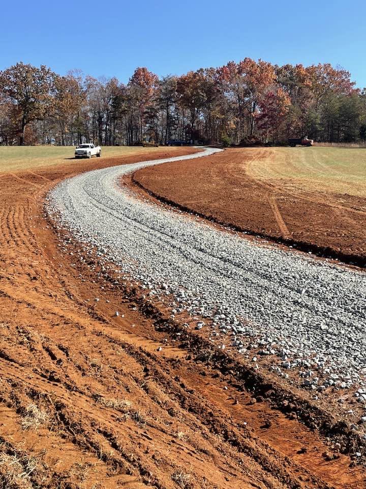 Finished curved gravel driveway through open field